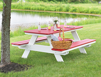 White picnic table with a red top and red, attached, benches.