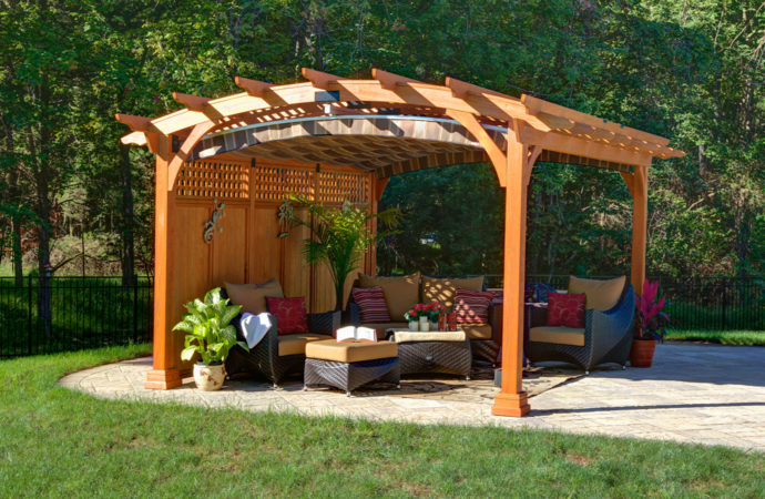 Arched pergola with a wooden privacy wall.