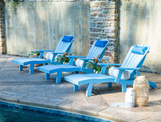 3 blue poly adirondack chaises by a pool